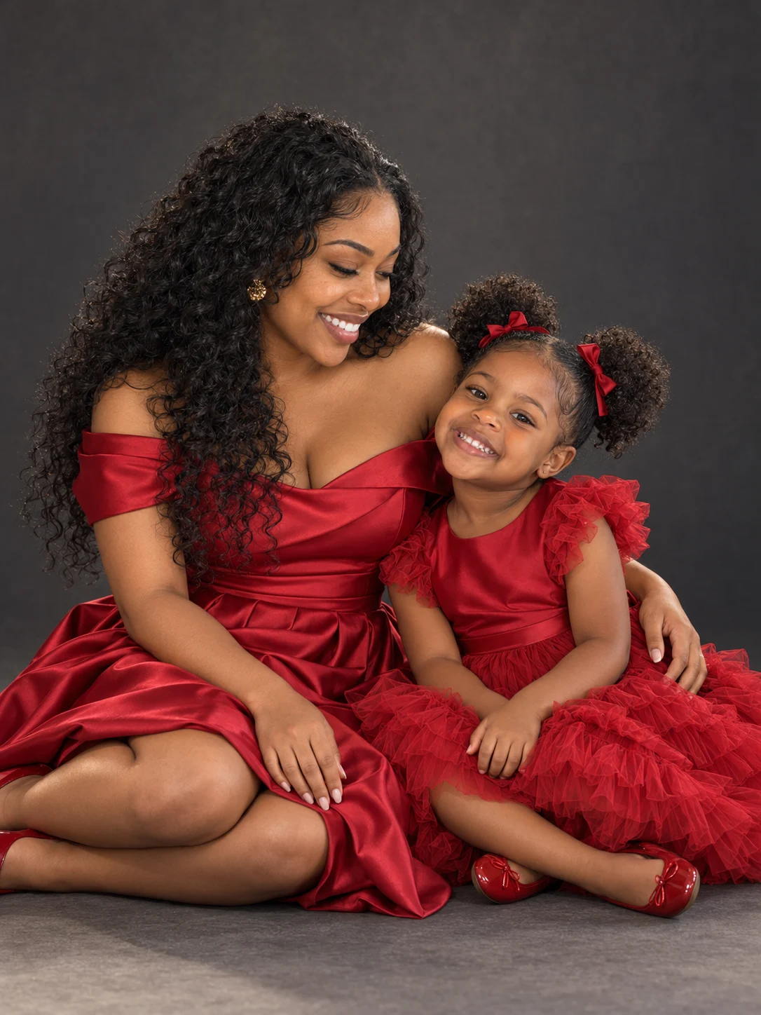 Mother and young daughter smiling in matching crimson dresses